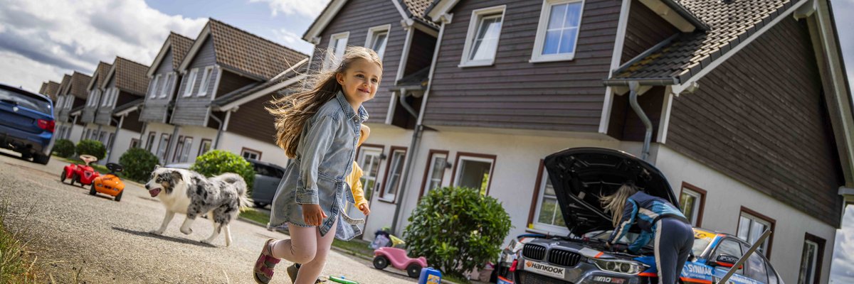 Familienurlaub im Nürburgring Ferienpark mit Kind, Hund und Rennwagen vor den Ferienhäusern
