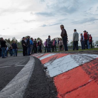 Besuchergruppe beim Trackwalk an der Nordschleife am Nürburgring, direkt auf den rot-weißen Curbs