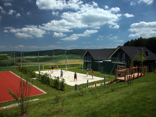 Ferienpark Nürburgring mit Volleyballfeld, Sportplätzen und Ferienhäusern in der Natur