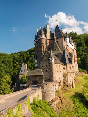 Burg Eltz in Rheinland-Pfalz umgeben von Wald und Natur bei Sonnenschein
